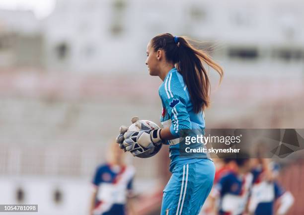female soccer goalkeeper with a ball on a stadium. - goalkeeper stock pictures, royalty-free photos & images