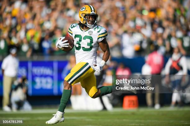 Running back Aaron Jones of the Green Bay Packers looks back as he steps into the end zone for a touchdown in the third quarter against the Los...