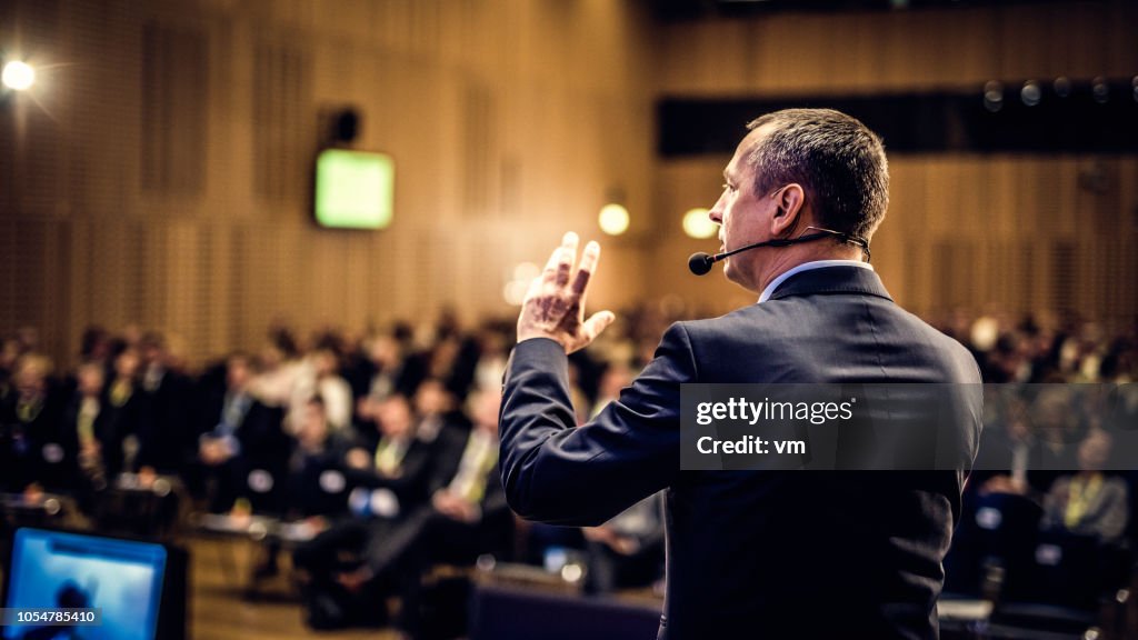 Rear view of a motivational coach giving a speech