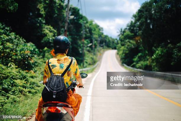 young woman on a motorcycle riding on ko phangan, thailand - woman riding scooter stock pictures, royalty-free photos & images