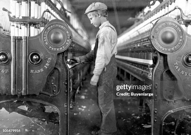 Young doffer boy works among the machines in a Lincolnton mill, North Carolina, 1908.