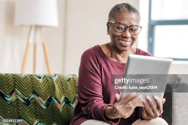 online-ärzte beratung - african american woman with tablet stock-fotos und bilder