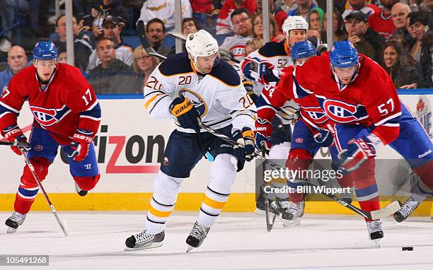 Rob Niedermayer of the Buffalo Sabres battles for the puck against Benoit Pouliot of the Montreal Canadiens as teammate Dustin Boyd looks on during...