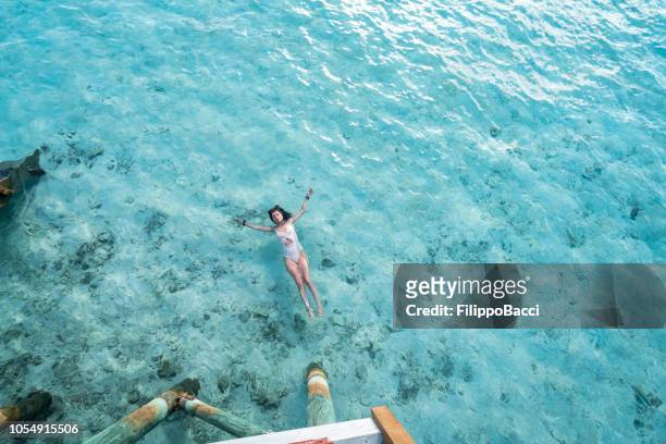 young adult woman relaxing in the sea - aerial beach view sunbathers stock pictures, royalty-free photos & images