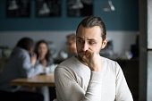 Upset male outcast feel lonely sitting alone in cafe