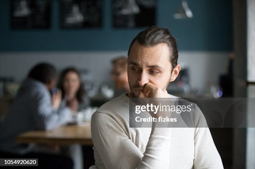 Upset male outcast feel lonely sitting alone in cafe Upset male outcast feel lonely sitting alone in cafe