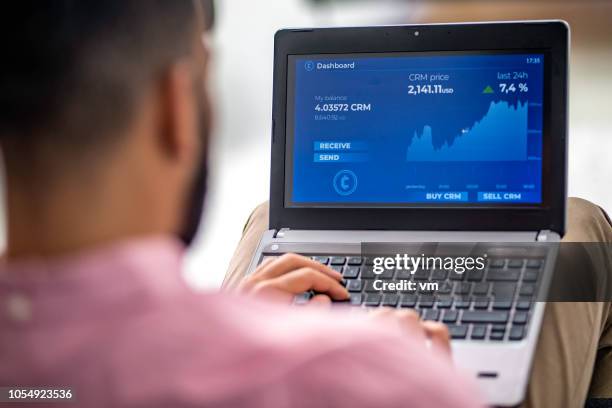 homem, analisando o gráfico financeiro em seu laptop - sobre os ombros - fotografias e filmes do acervo