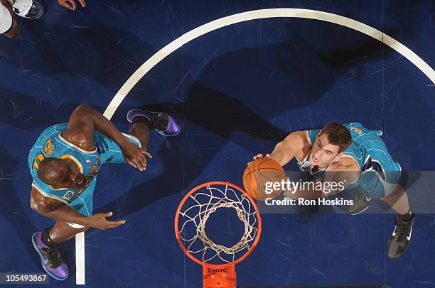 Jason Smith and Emeka Okafor of the New Orleans Hornets rebound against the Indiana Pacers on October 15, 2010 at Conseco Fieldhouse in Indianapolis,...