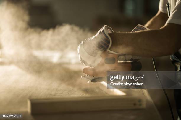cerca de albañil hombre trabajando con lijadora en un tablón de madera. - pulidora fotografías e imágenes de stock