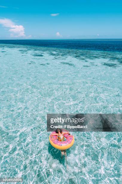 young adult woman relaxing on inflatable in the sea - aerial beach view sunbathers stock pictures, royalty-free photos & images