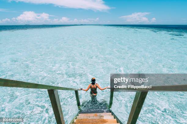 jeune femme adulte en descendant vers la mer - paysage voyage photos et images de collection