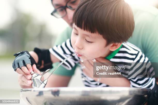 little boy drinking tap water - drinking fountain stock pictures, royalty-free photos & images