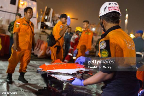 Search and rescue workers s sift through the remains of the Lion Air flight JT 610 into a waiting ambulance at the Tanjung Priok port on October 29,...