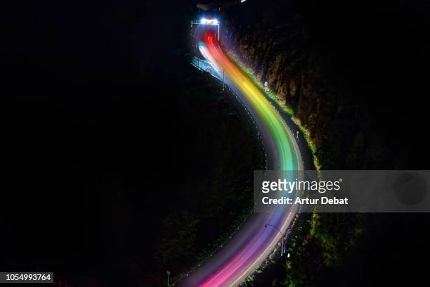 aerial road at night with rainbow light trail effect. - dark country road stock pictures, royalty-free photos & images
