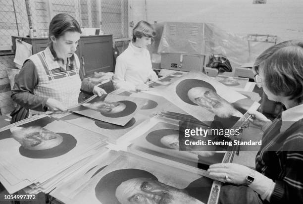 Three women preparing printed portraits of Iranian Shia Islam religious leader and politician Ruhollah Khomeini, UK, 15th November 1979.