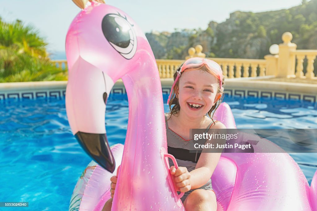Young girl on inflatable flamingo