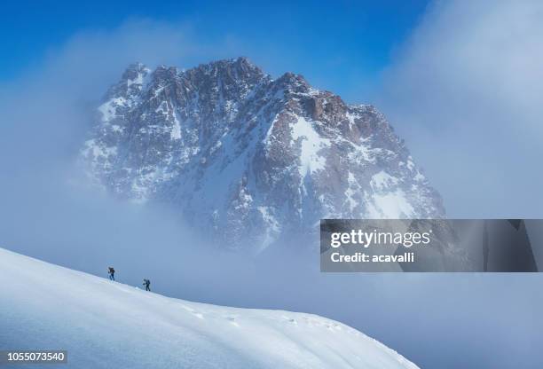 bergsteiger auf einen verschneiten hang. - courmayeur stock-fotos und bilder