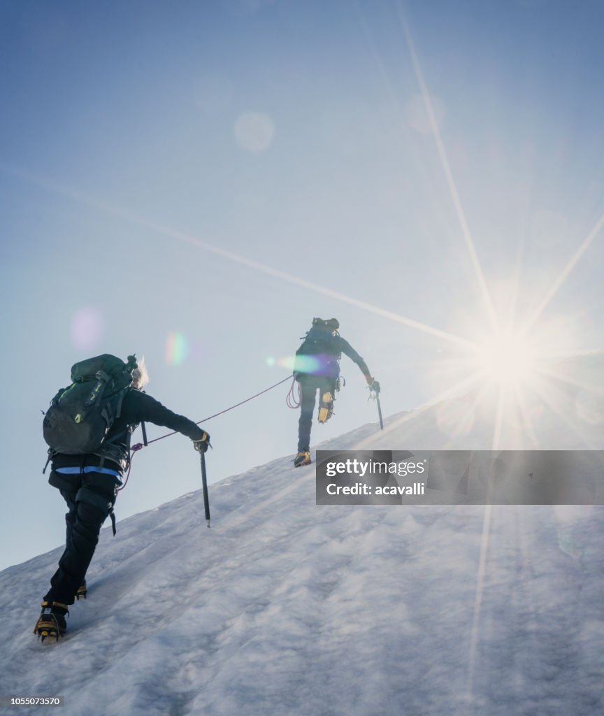 Alpinistes sur une pente enneigée.