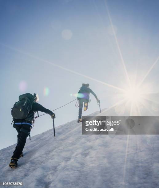 climbers on a snowy slope. - teamwork mountain stock pictures, royalty-free photos & images