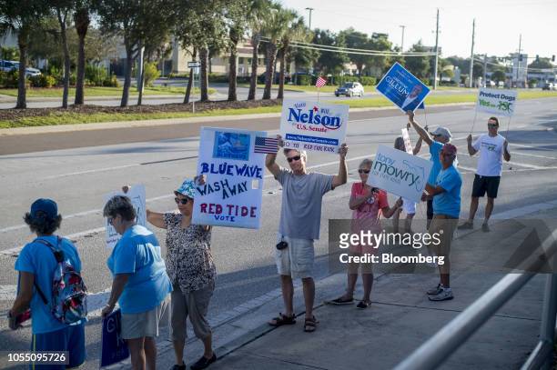 Demonstrators hold signs during a protest in Englewood, Florida, U.S., on Wednesday, Oct. 17, 2018. Mother nature is never far away in Florida, where...
