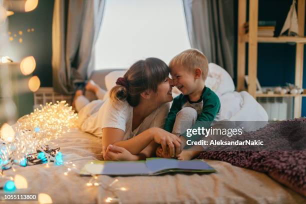 mom is reading bedtime stories - two boys in bed stock pictures, royalty-free photos & images