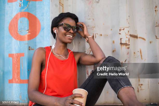 Woman with coffee cup listening to headphones
