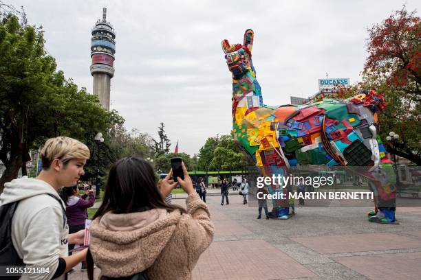 An eight-metre-high Andean llama made with scrap, waste and plastics by artists from the study Embroidery 2 of Portugal is seen on a pedestrian walk...