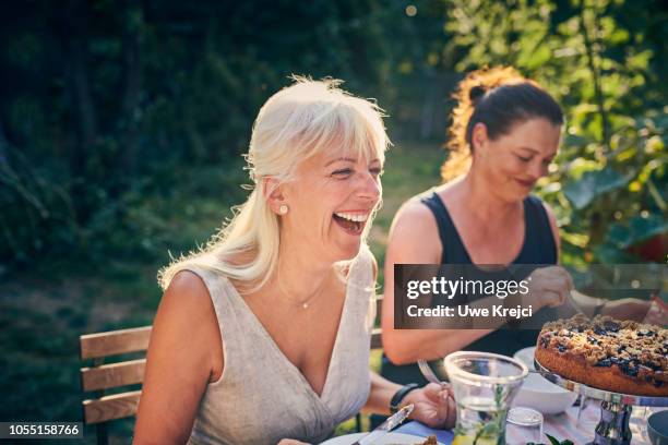 mature woman laughing at garden party - mature women eating stock pictures, royalty-free photos & images