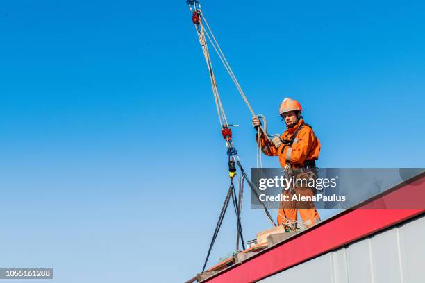 firefighter in a rescue operation using a crane - accident on the roof - rope high rescue imagens e fotografias de stock