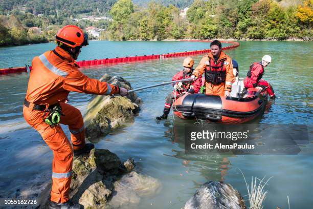 costruzione della diga sul fiume - operazione di salvataggio con una barca, fuoriuscita di petrolio - evento catastrofico foto e immagini stock