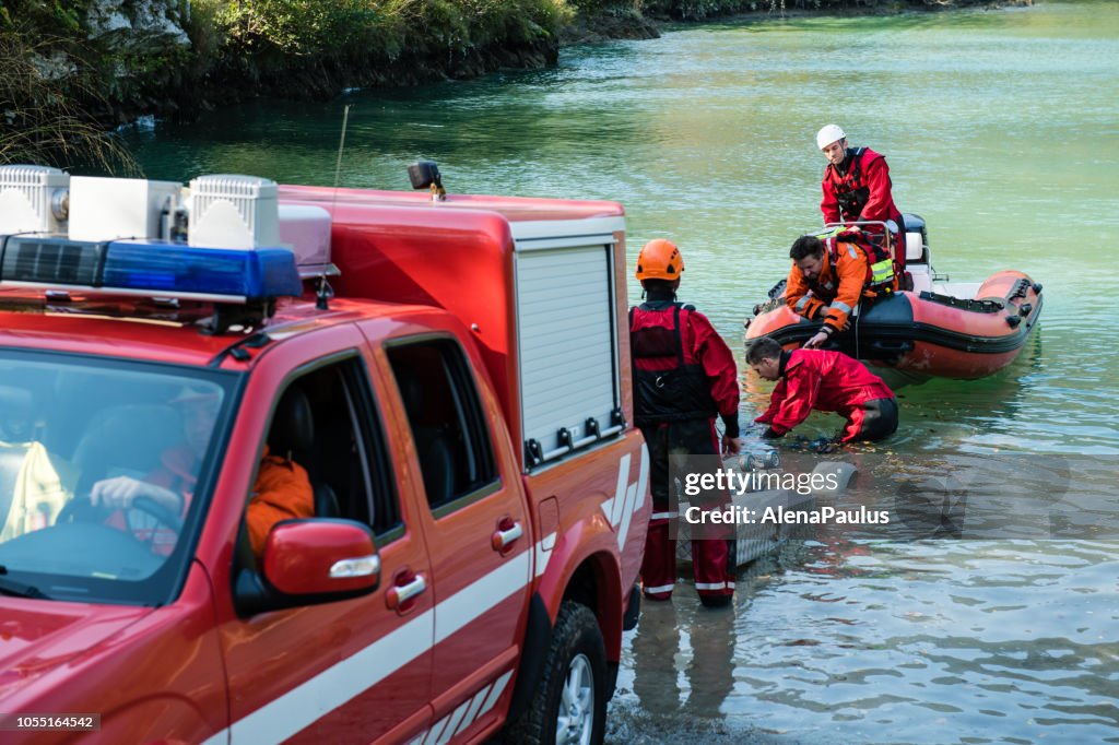 Dammbau am Fluss - Rettungsaktion mit einem Boot, Ölpest