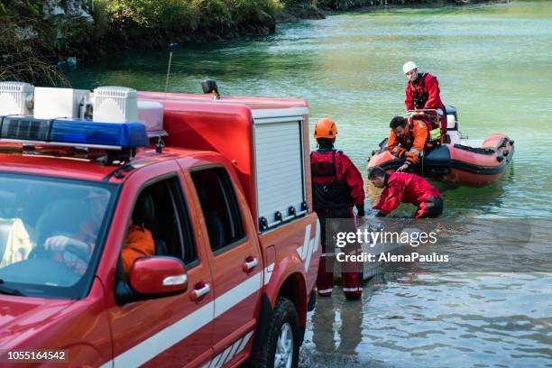 dammbau am fluss - rettungsaktion mit einem boot, ölpest - rescue worker stock-fotos und bilder