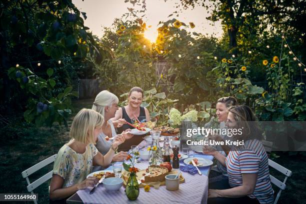 group of women having dinner in garden - mature women eating stock pictures, royalty-free photos & images