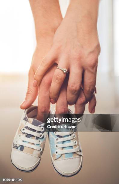 happy couple expecting baby - baby booties imagens e fotografias de stock