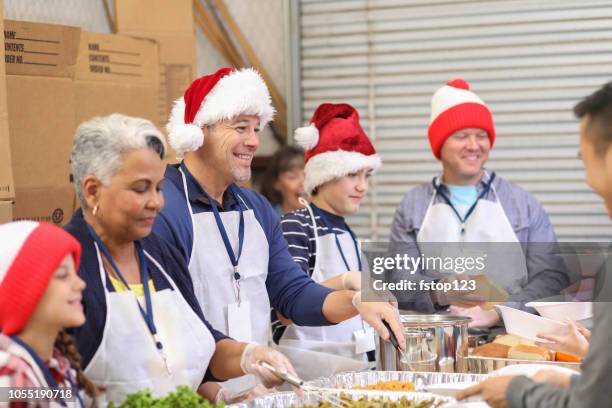 multi-ethnische freiwilligen gerichte in suppenküche zu weihnachten. - soup kitchen stock-fotos und bilder