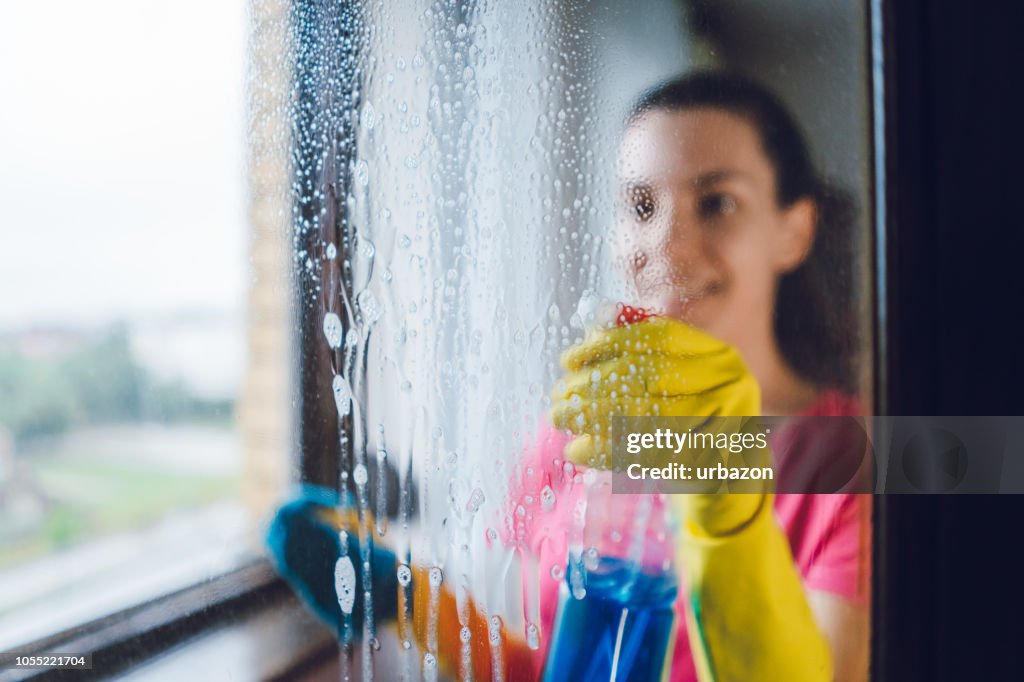 Junge Frau waschen Fenster
