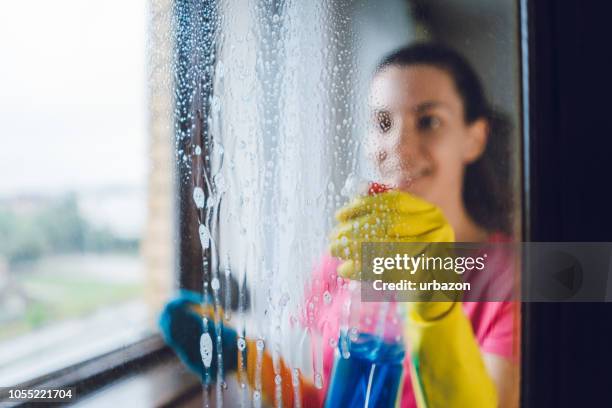 jonge vrouw wassen venster - schoon stockfoto's en -beelden