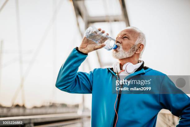 trinkwasser nach dem joggen - lap body area stock-fotos und bilder