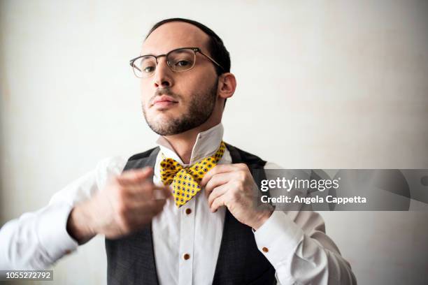 businessman putting on bow tie - bow tie stock pictures, royalty-free photos & images