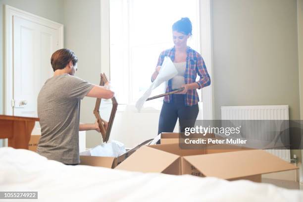 couple packing mirror into cardboard box - oggetti personali foto e immagini stock
