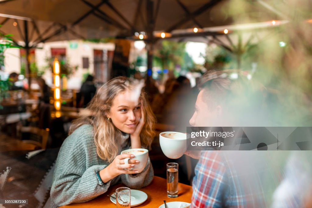 Pareja joven disfrutando de su café en un bar