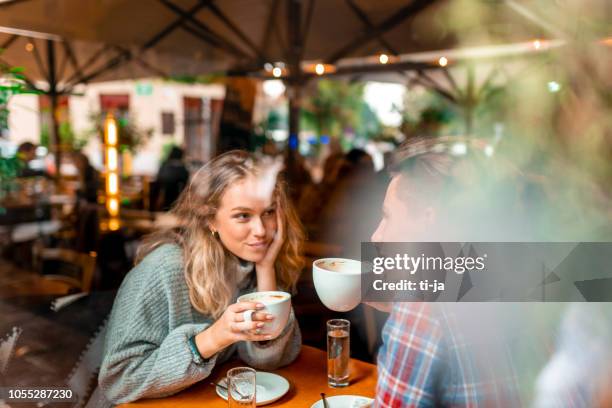 jong koppel genietend van hun koffie in een bar - date stockfoto's en -beelden