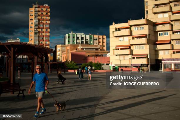 Man walks with his dog in La Linea de la Concepcion, on October 16, 2018. - Gibraltar has close to full employment and it has long been a lifeline...