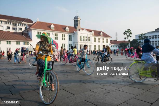 bicycling around fatahillah square in jakarta's old town - jakarta stock pictures, royalty-free photos & images