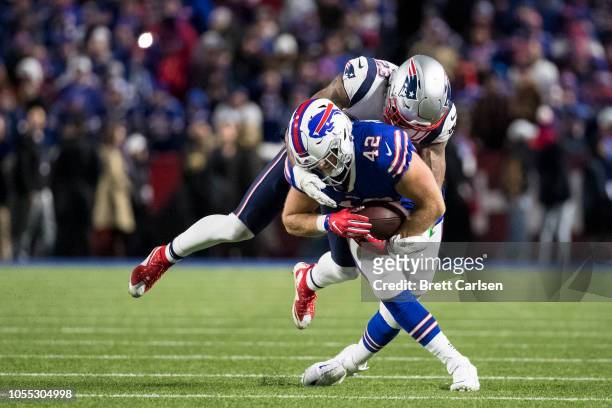 Patrick DiMarco of the Buffalo Bills is brought down by Patrick Chung of the New England Patriots during the second quarter at New Era Field on...