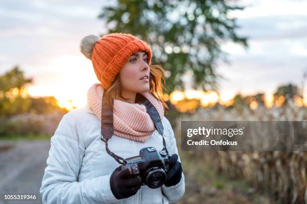 beautiful young woman taking picture with digital camera at sunset - toque stock pictures, royalty-free photos & images