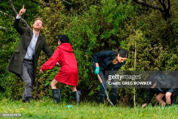 Britain's Prince Harry and Meghan, Duchess of Sussex plant Puriri and Kowhai trees with the help from 11 year-old Isabella Iti and 11 year-old Alex...
