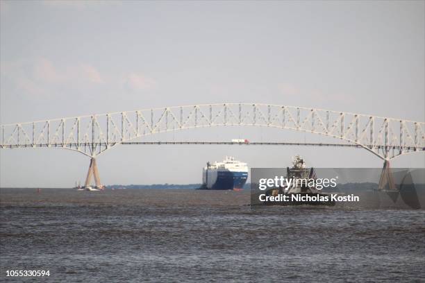 small tugboat and large automobile cargo ship - baltimore maryland photos et images de collection