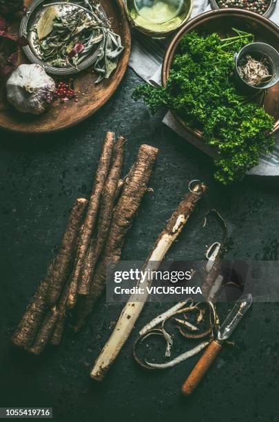 black salsify peeling on kitchen table with knife and ingredients, top view - salsify stock-fotos und bilder