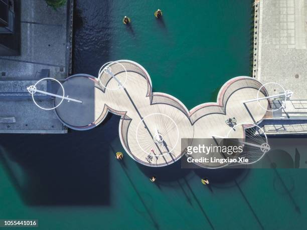 aerial view of the circle bridge (cirkelbroen) on the inner harbor of copenhagen, denmark. taken by drone from straight above. - copenhagen bicycle stock pictures, royalty-free photos & images